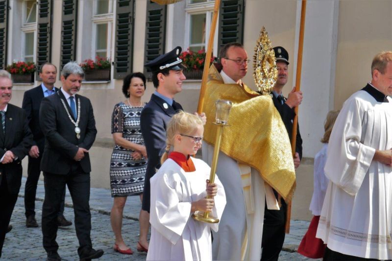 Pfarrer Seidl mit der Monstranz unter dem Baldachin, Bürgermeister Bauer mit der Amtskette, Sprecherin des Pfarrgemeinderat und Mitglieder des Stadtrat.