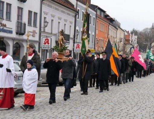 Prozession über den Stadtplatz. Angeführt von Ministranten wird die Statue des Hl. Sebastian vor den Vereinsabordnungen getragen.